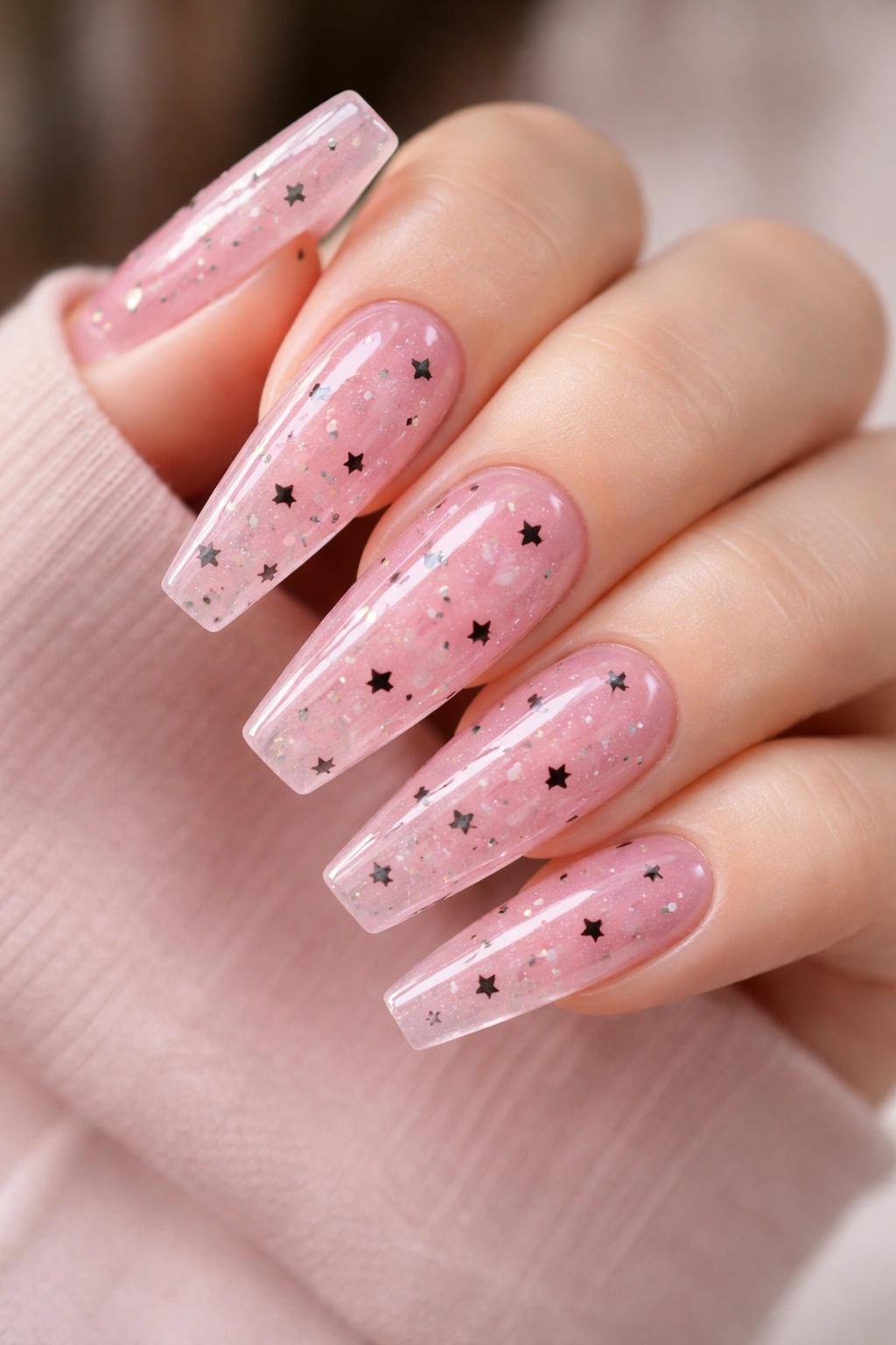 Pink jelly coffin nails with tiny black stars embedded