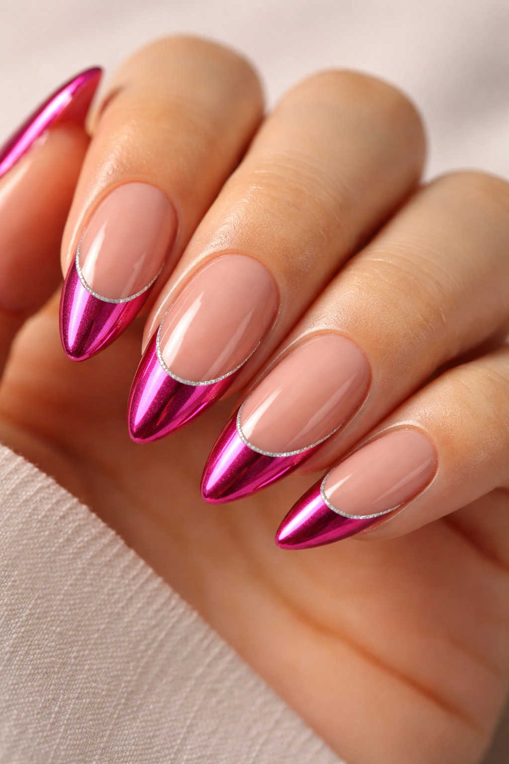 Almond nails with nude base and hot pink tips separated by a thin silver line