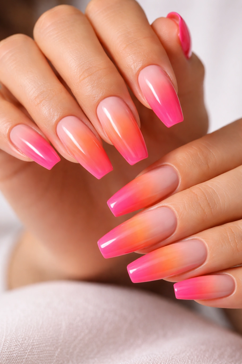 Coffin nails with pink to orange ombré gradient and glossy finish