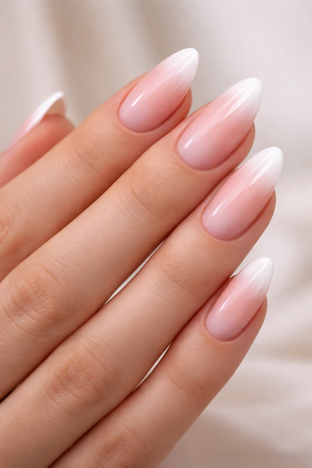 Almond nails with pink to white French ombre and slim white tip