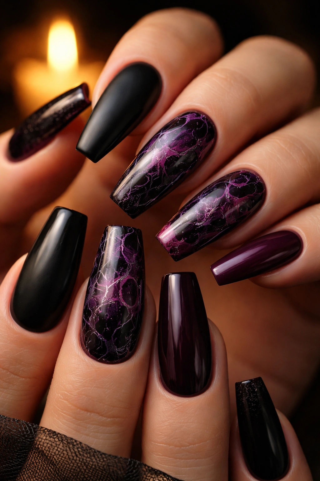 Plum and black marble coffin nails with two marble nails visible in warm candlelight