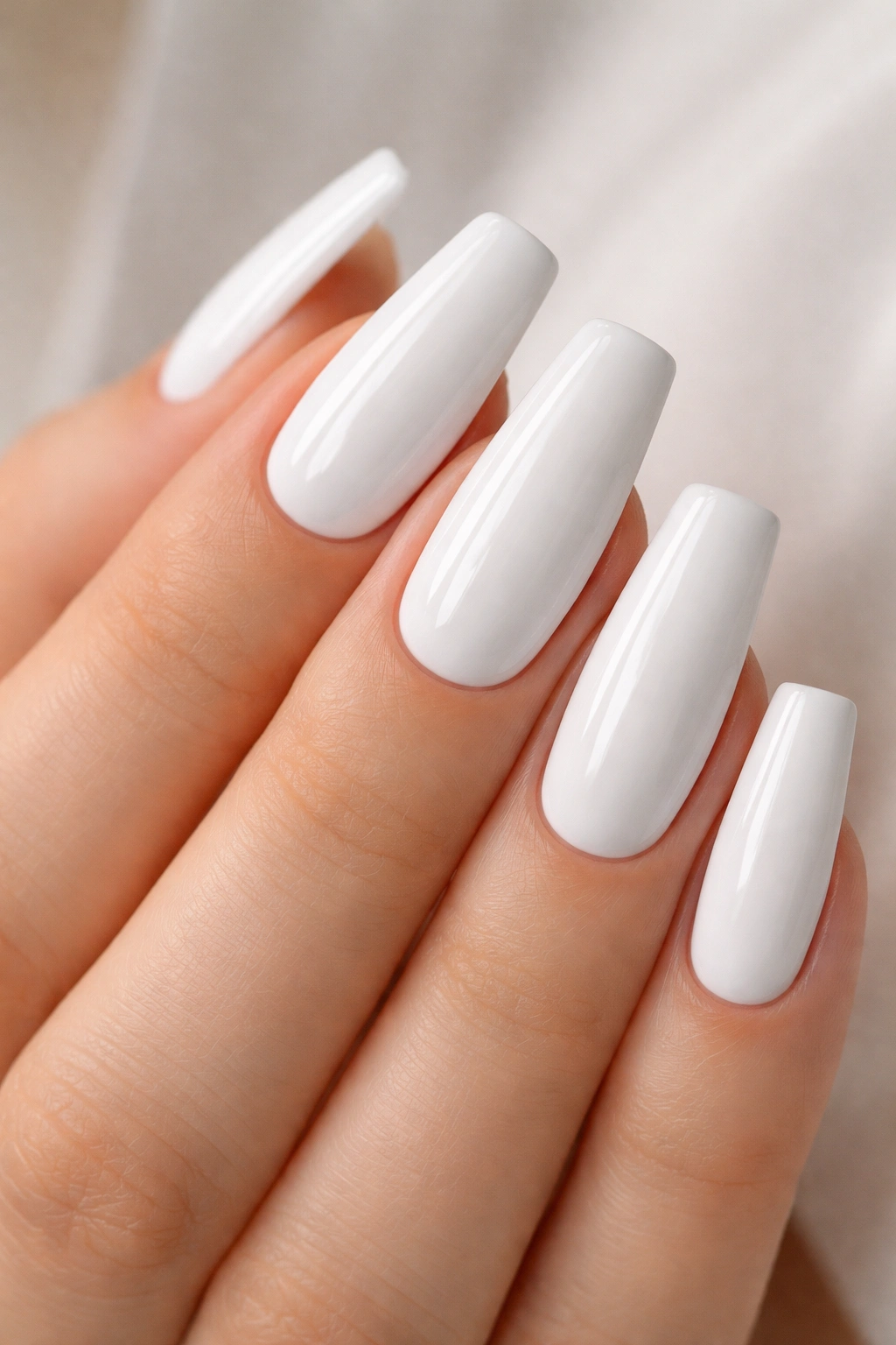 Close-up of opaque porcelain white nails with a mirror-like gloss.