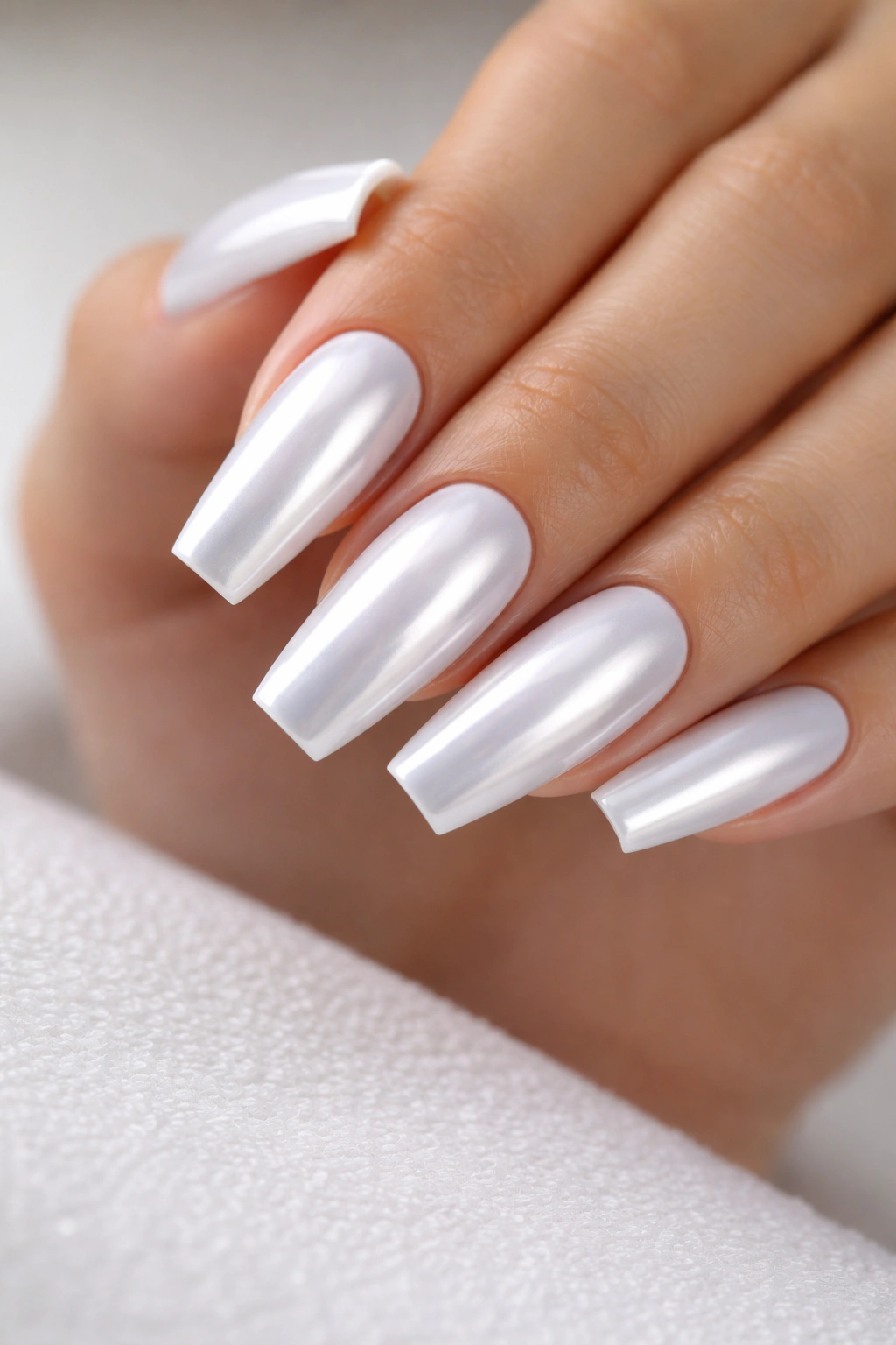 Close-up of coffin nails with pristine white chrome finish and sharp edges