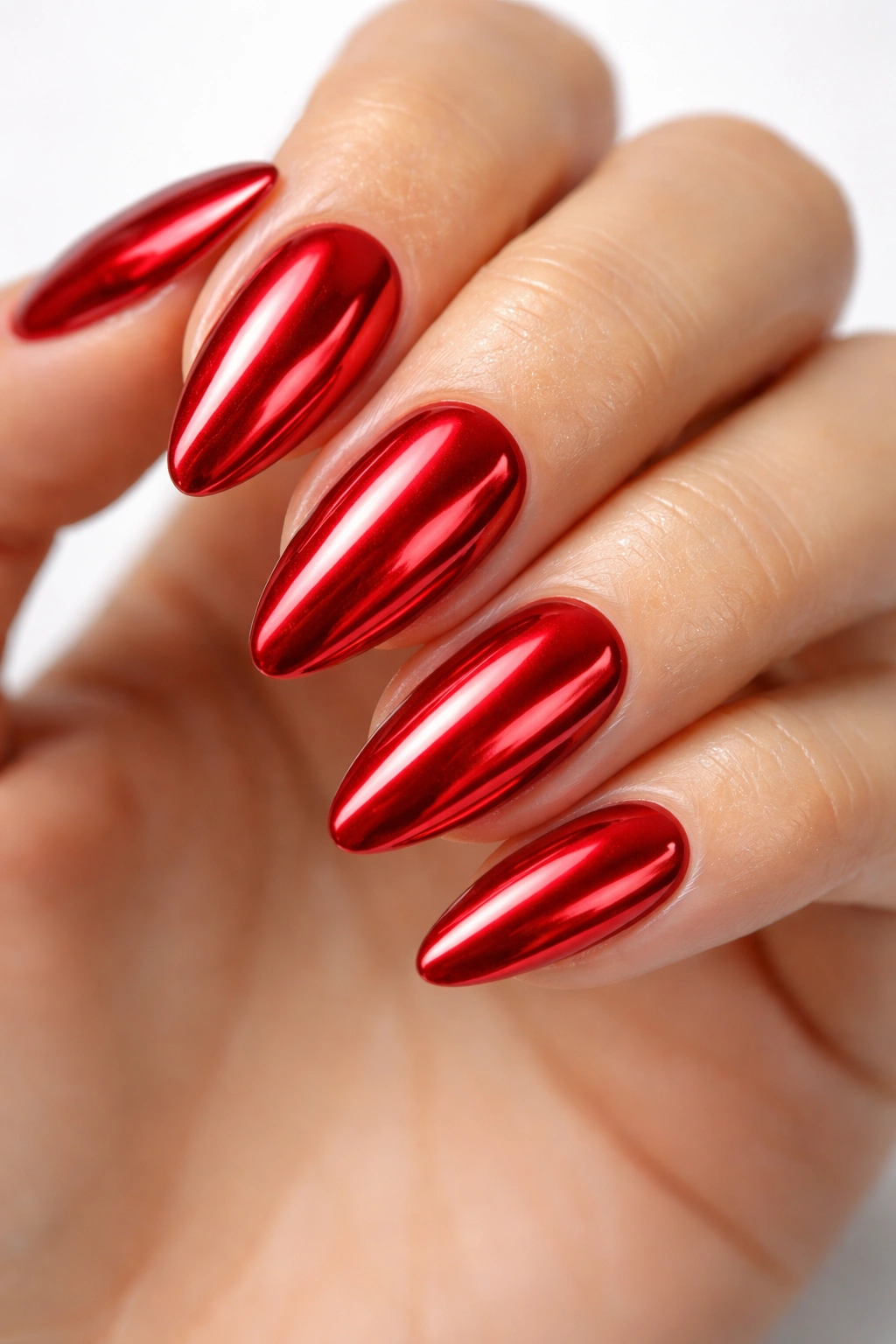 Close-up of almond-shaped nails with cherry red chrome mirror finish