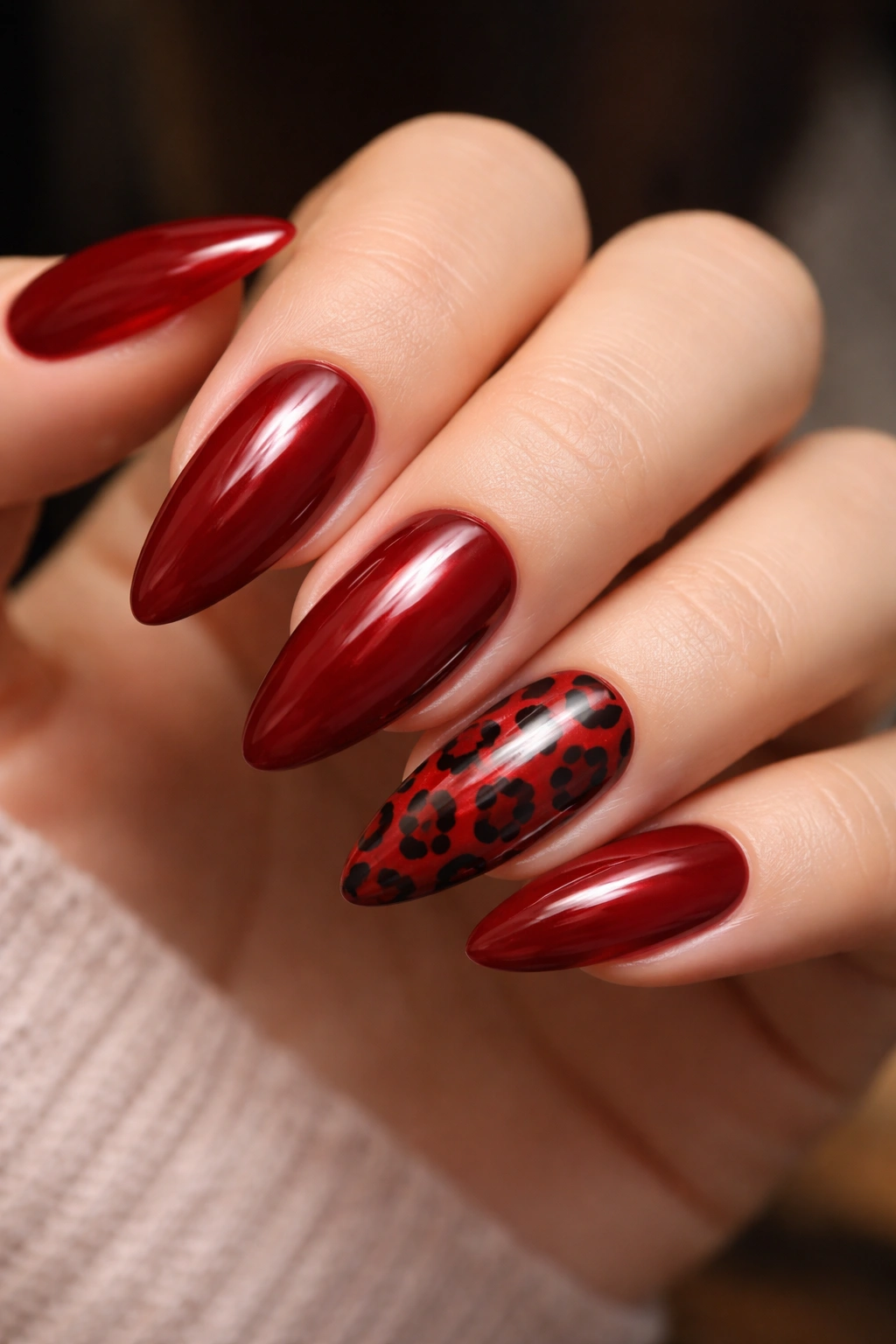 Red leopard print on almond nails with a dark red base and glossy finish.