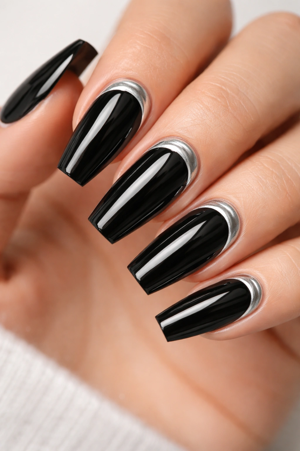 Close-up of reverse French black coffin nails with silver cuticle arcs