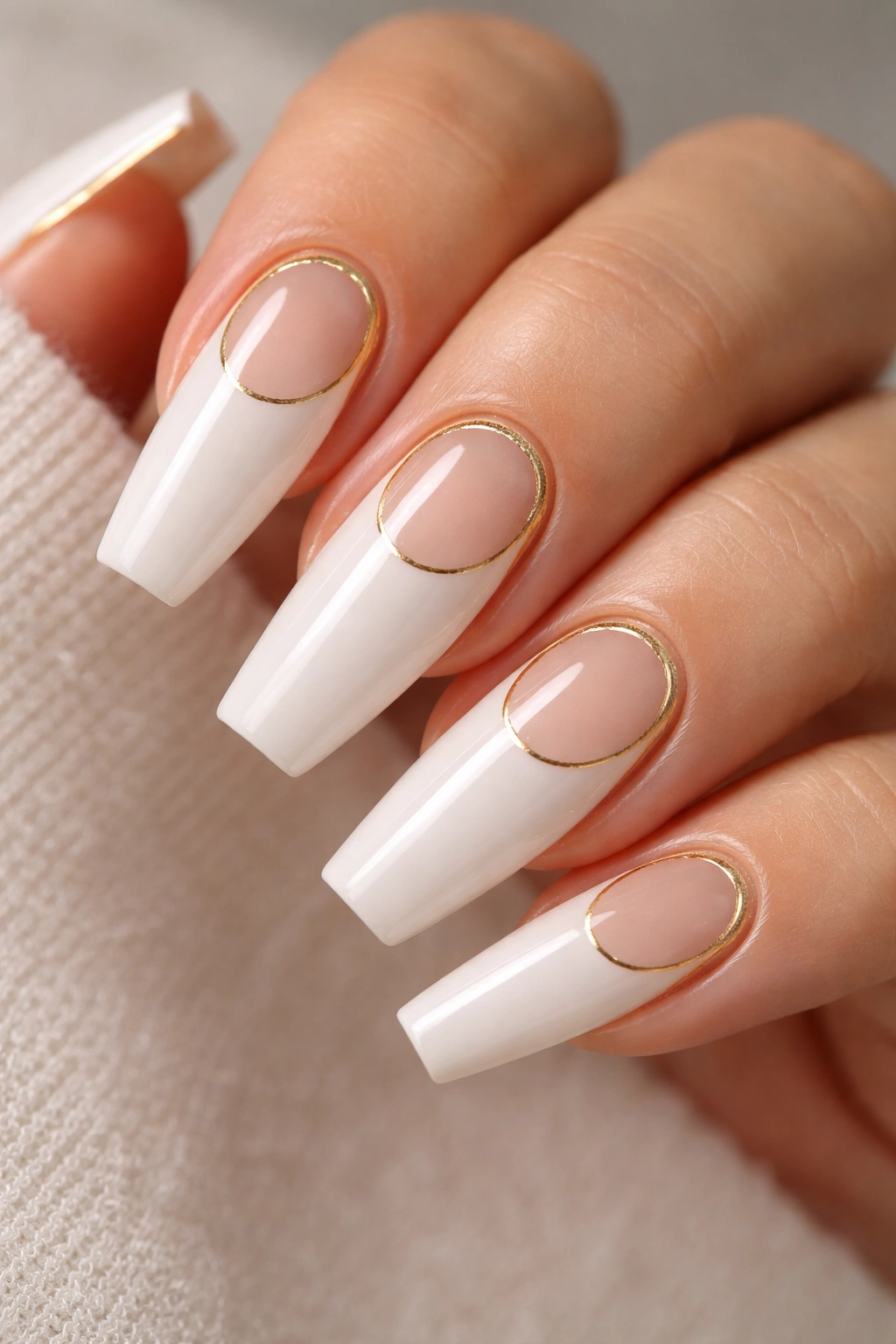 Close-up of reverse French coffin nails with a sheer crescent and gold outline