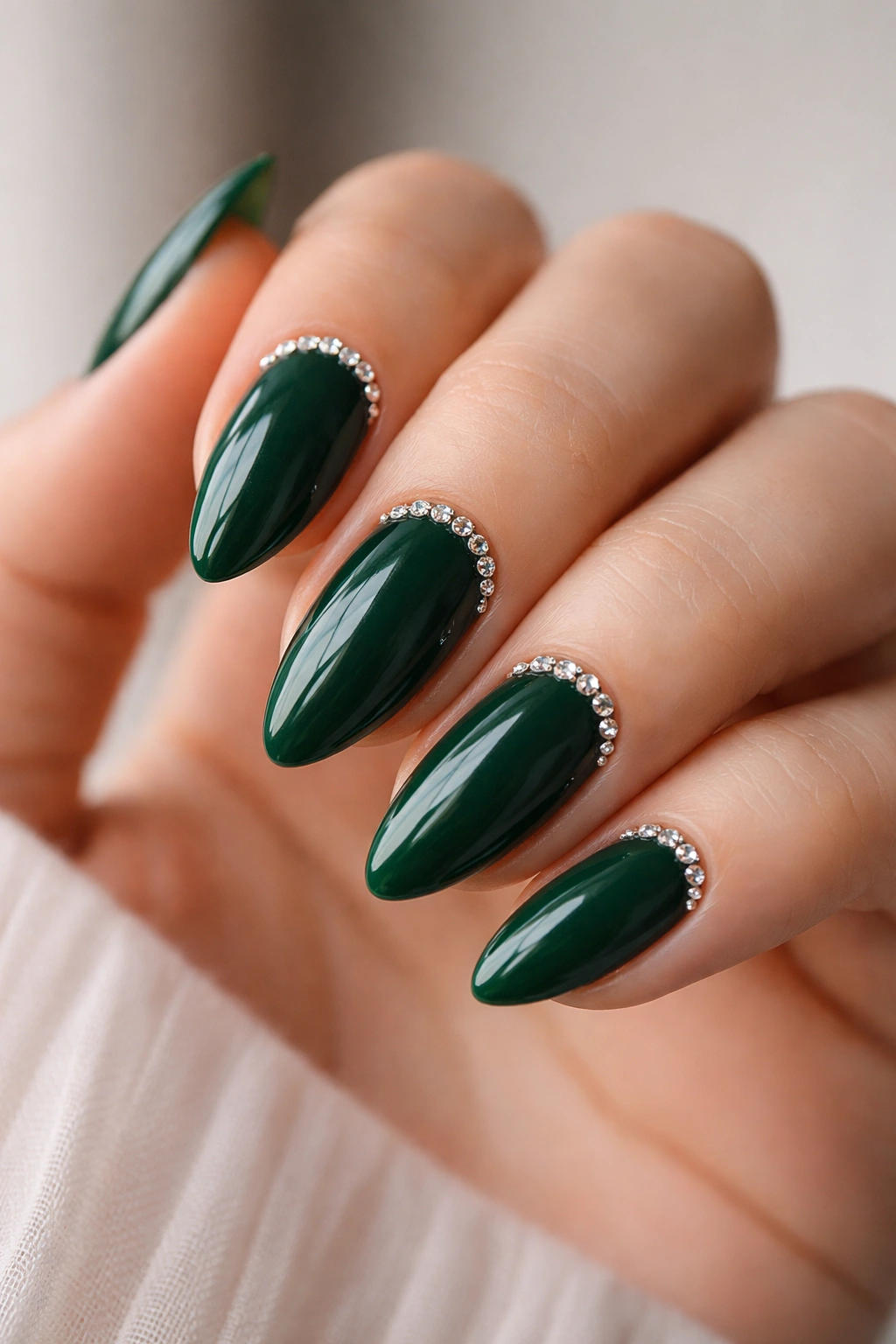 Emerald almond nails with rhinestones near the cuticle