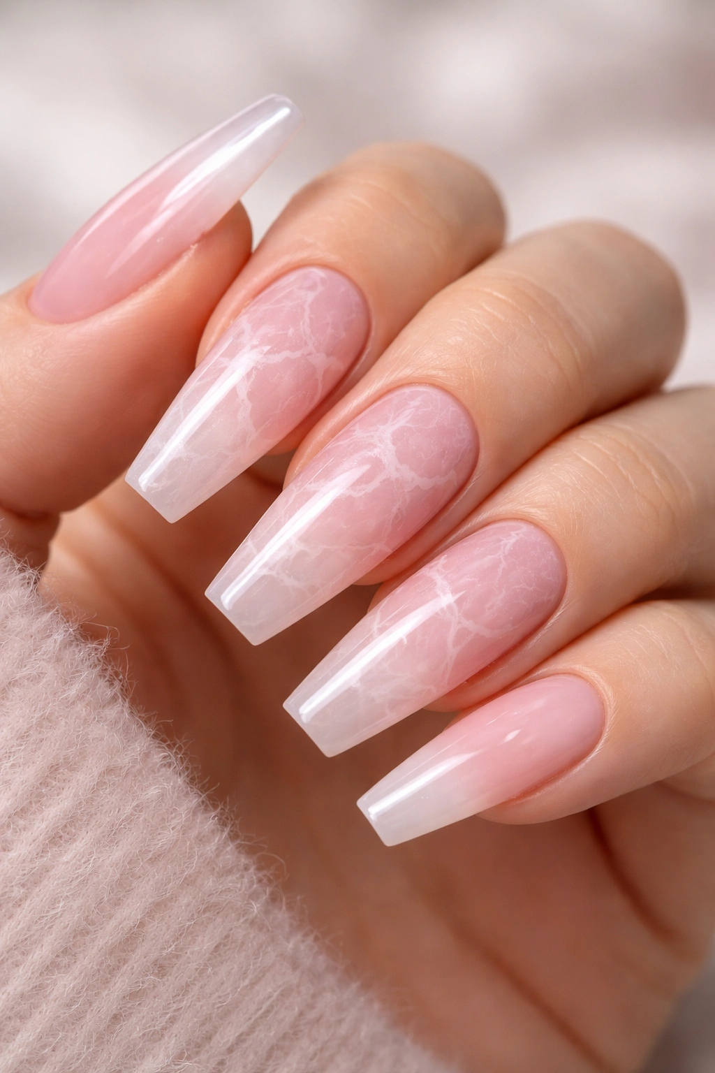 Close-up of rose quartz sheer marble coffin nails with pink translucence and white veining