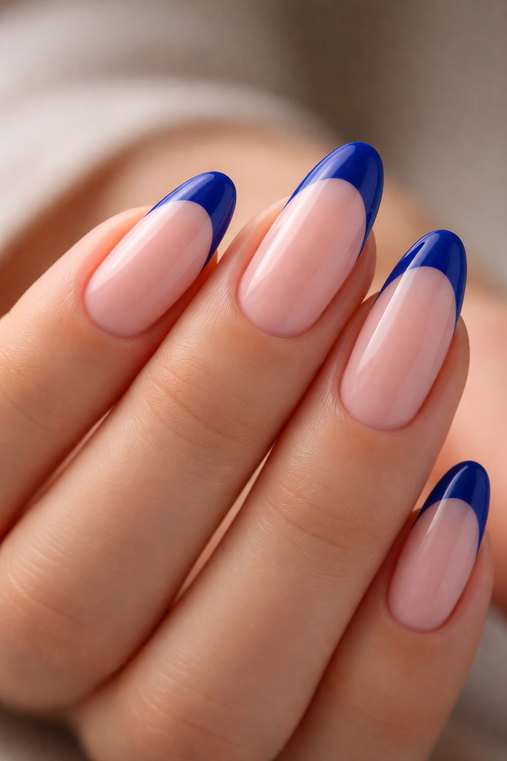 Almond nails with sheer pink base and royal blue French tips