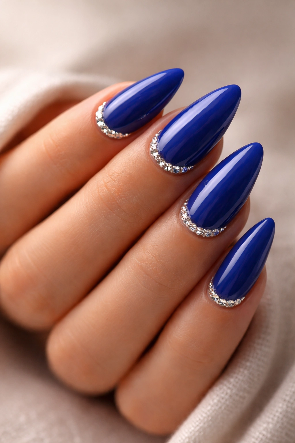 Almond nails with gemstone cuticle cuffs on royal blue polish