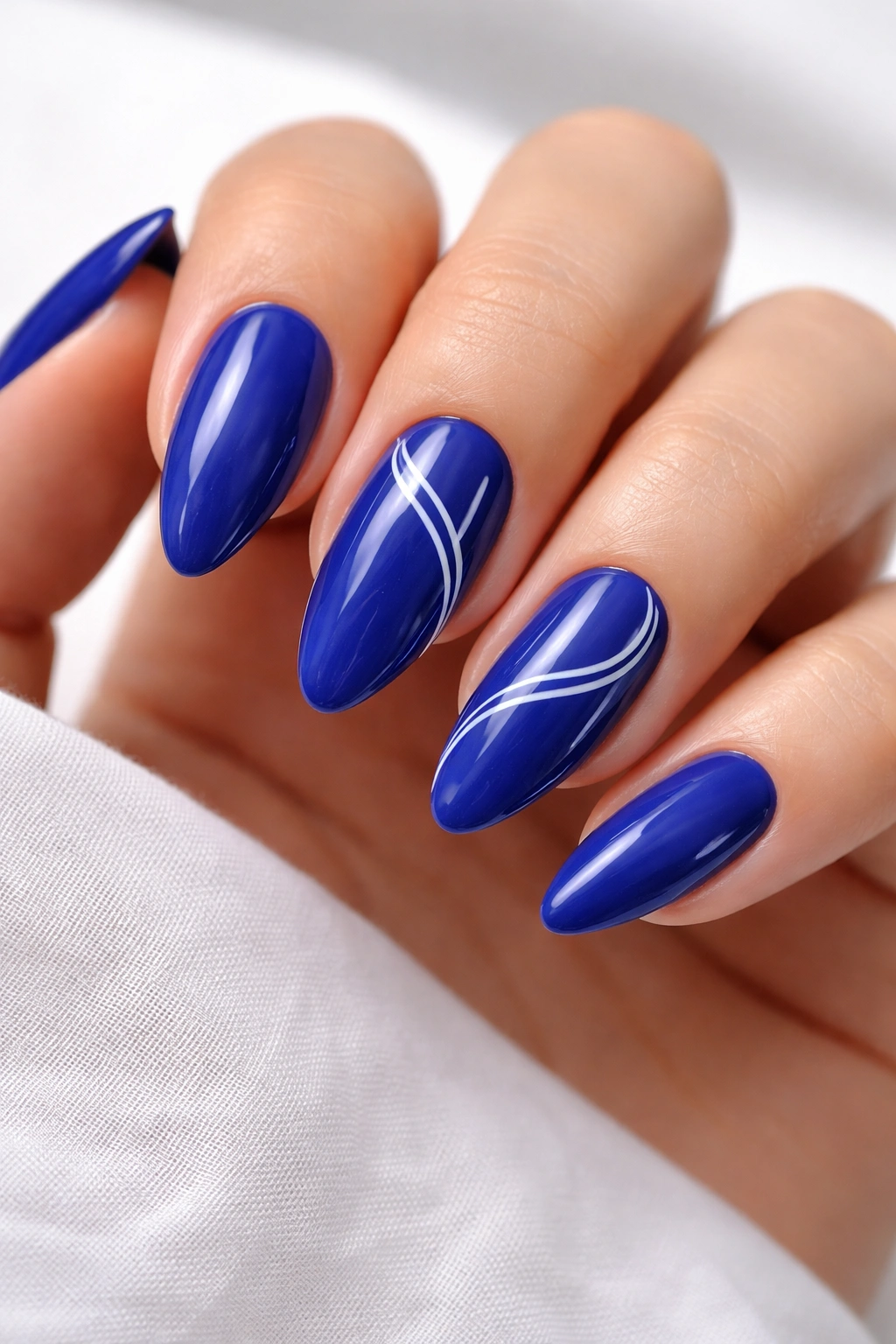 Almond nails with royal blue base and white linework