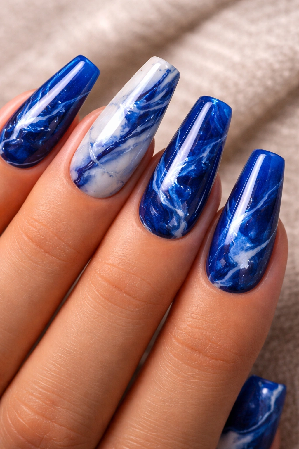 Royal blue marble coffin nails with varied veining and glossy wet depth