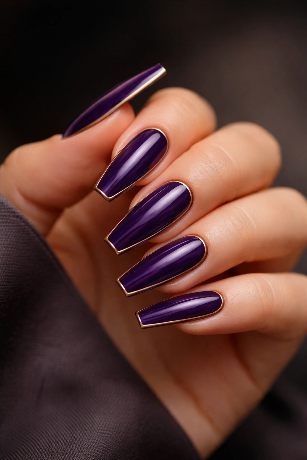Royal purple coffin nails with a delicate gold outline on select nails