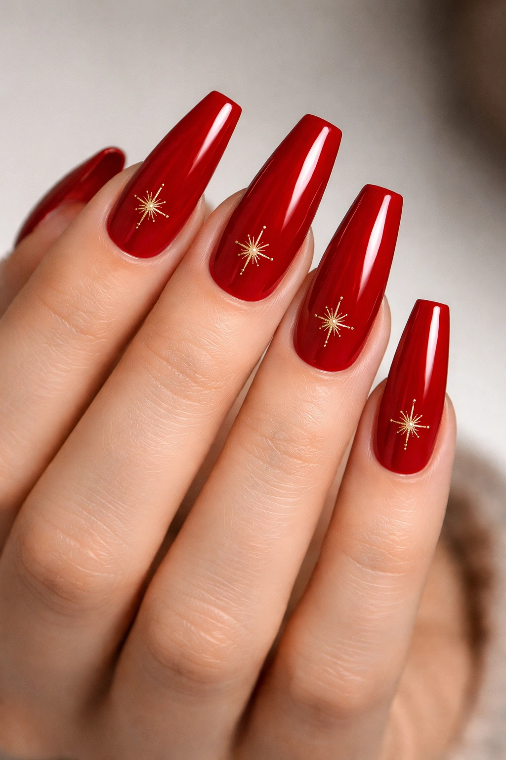 Scarlet coffin nails with gold starburst accents, photorealistic