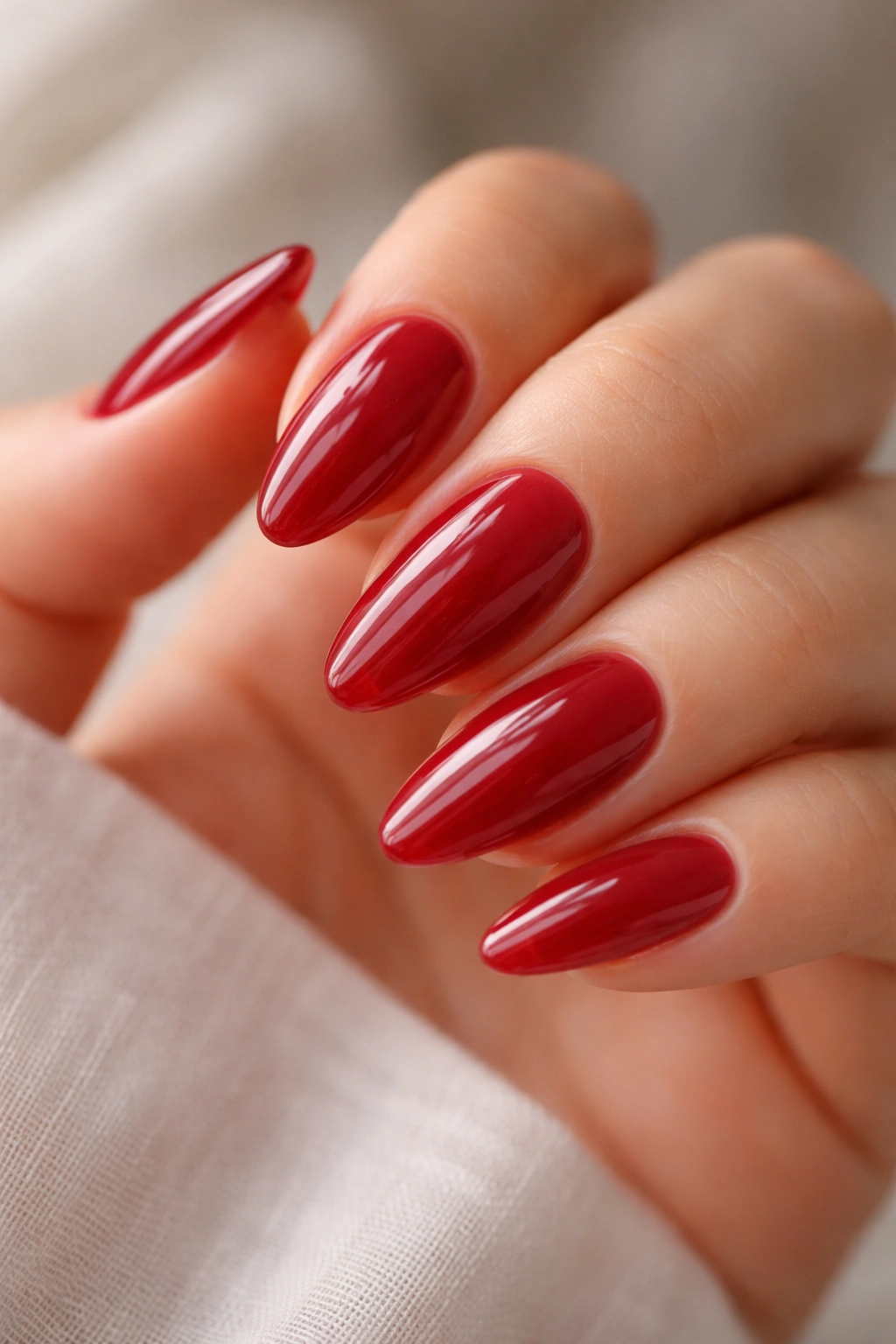 Almond nails with sheer jelly red color showing nail bed through translucent glaze