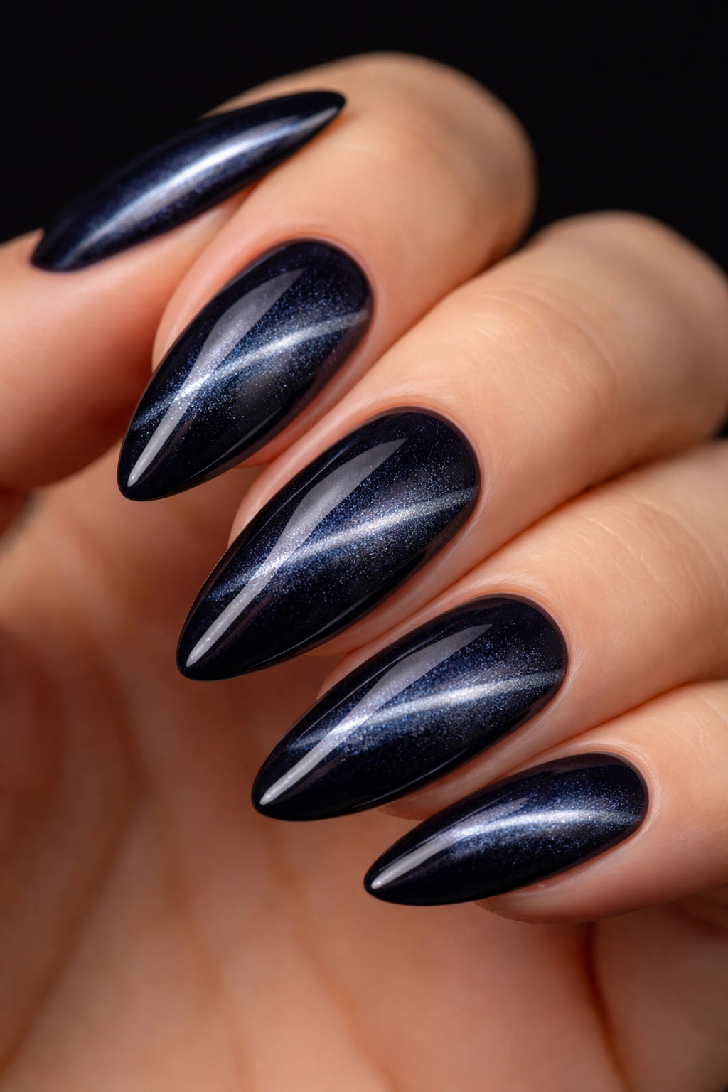 Almond nail with a diagonal side swept cat eye line on deep navy base