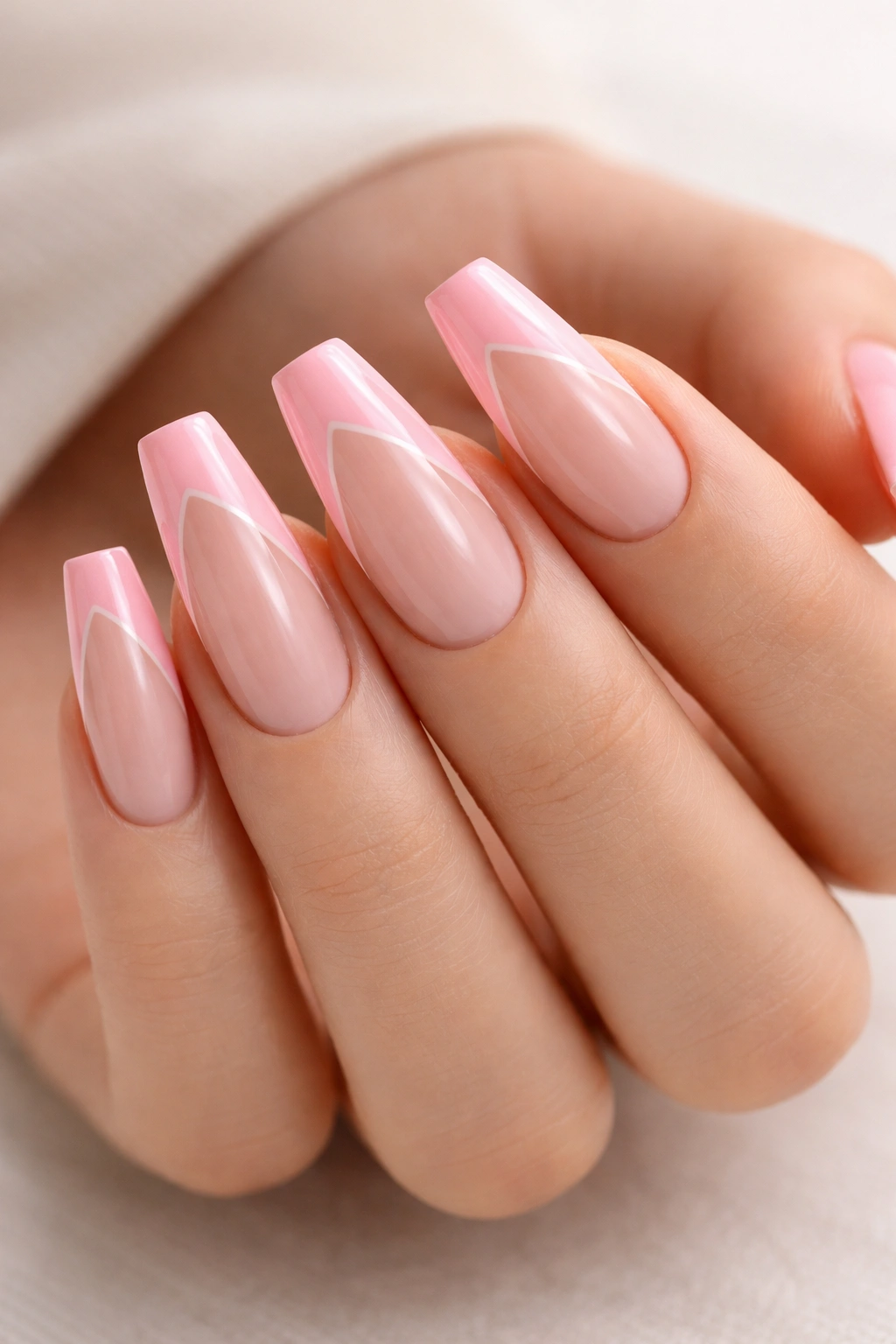 Close-up of side-swept pink French with negative space on medium coffin nails