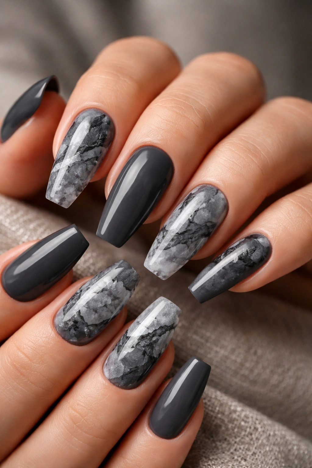Close-up of coffin-shaped nails with slate gray marble pattern and negative space