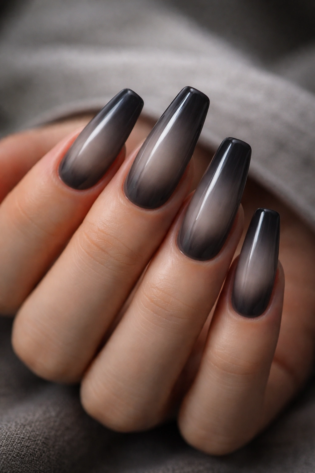 Close-up of smoke aura coffin nails with diffused gray glow on sheer base