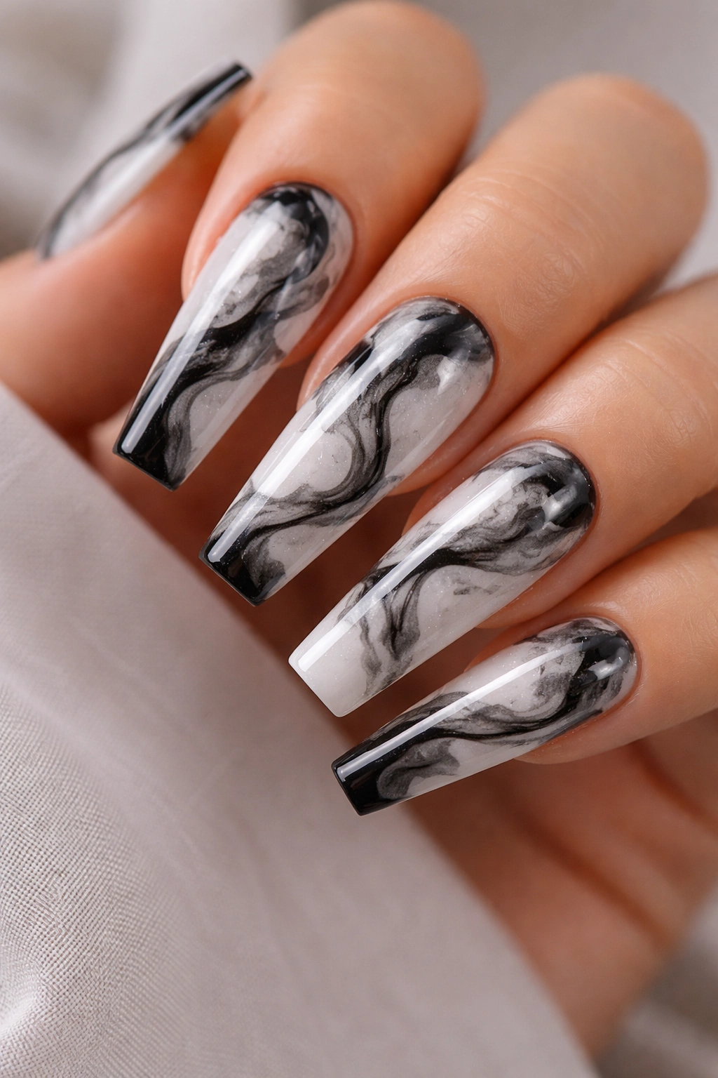 Coffin nails with milky white base and smoky black marble swirls, glossy finish.