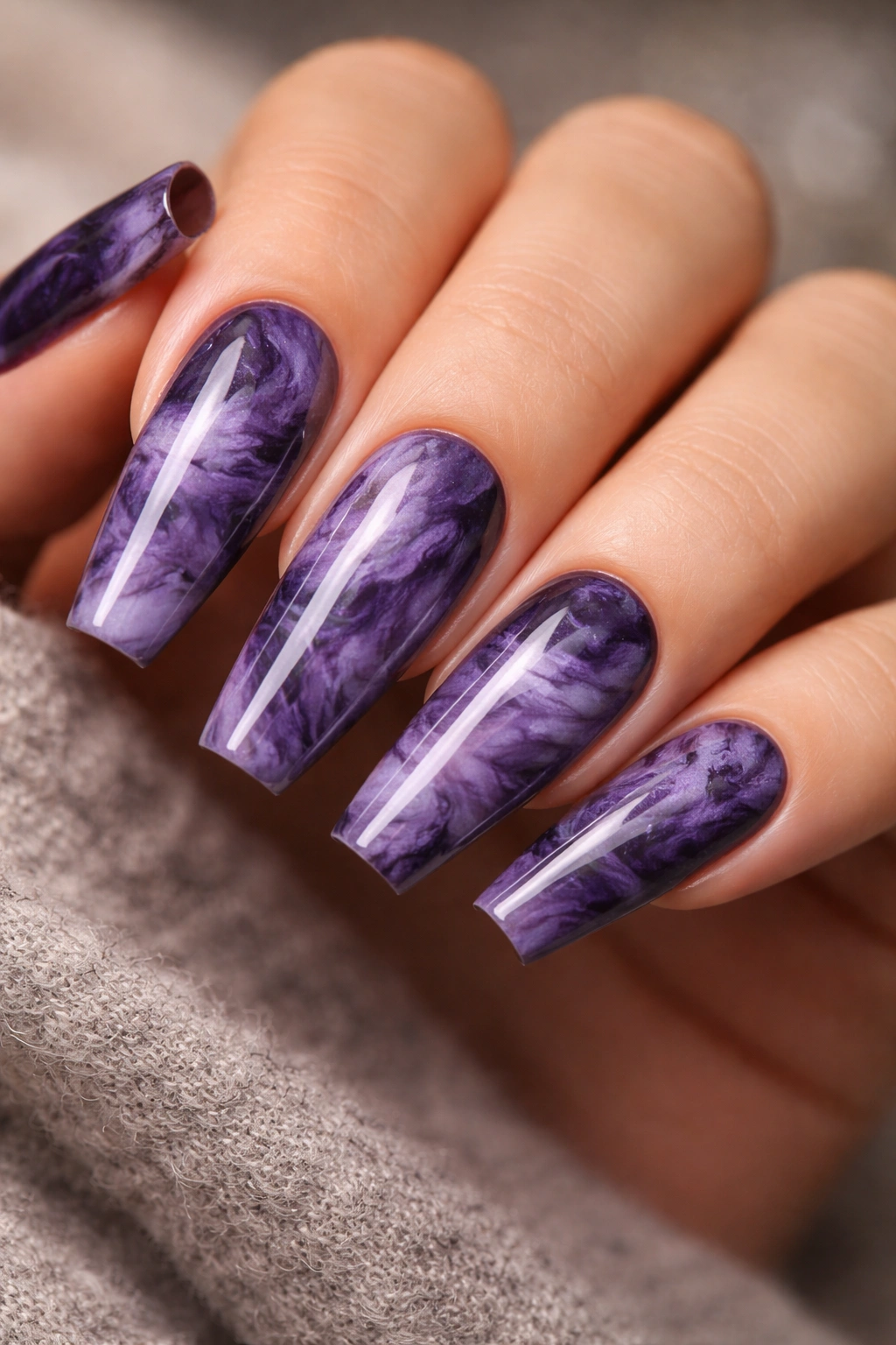 Close-up of smoky marble purple coffin nails with marbled swirls