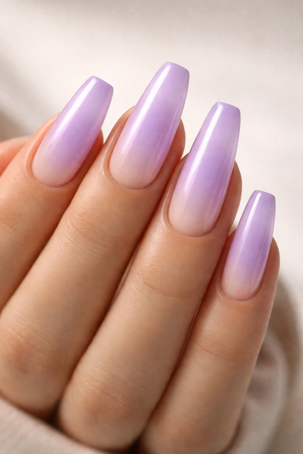 Close-up of soft aura purple coffin nails with a glowing center