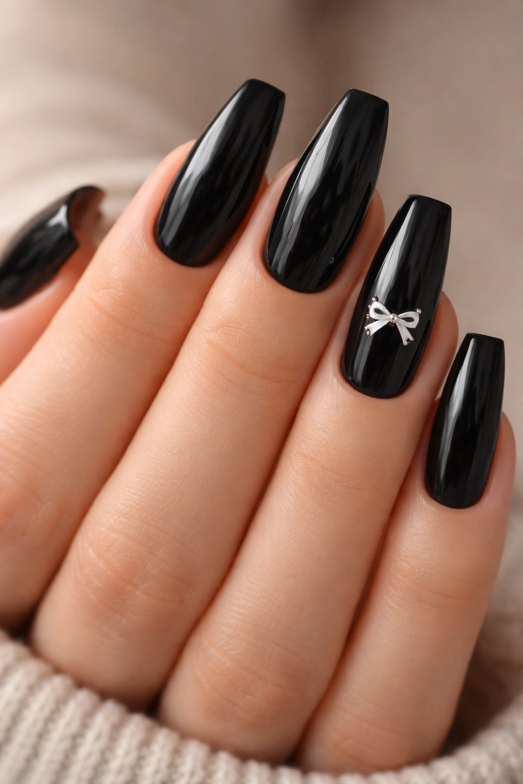 Soft black coffin nails with tiny white bow accents on two nails