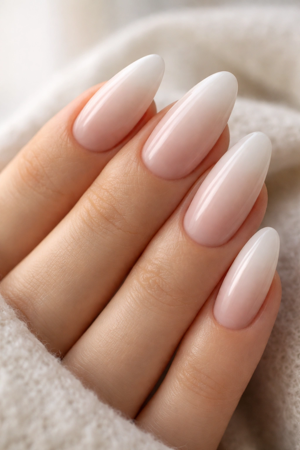 Almond nails with soft white ombré fade on nude base