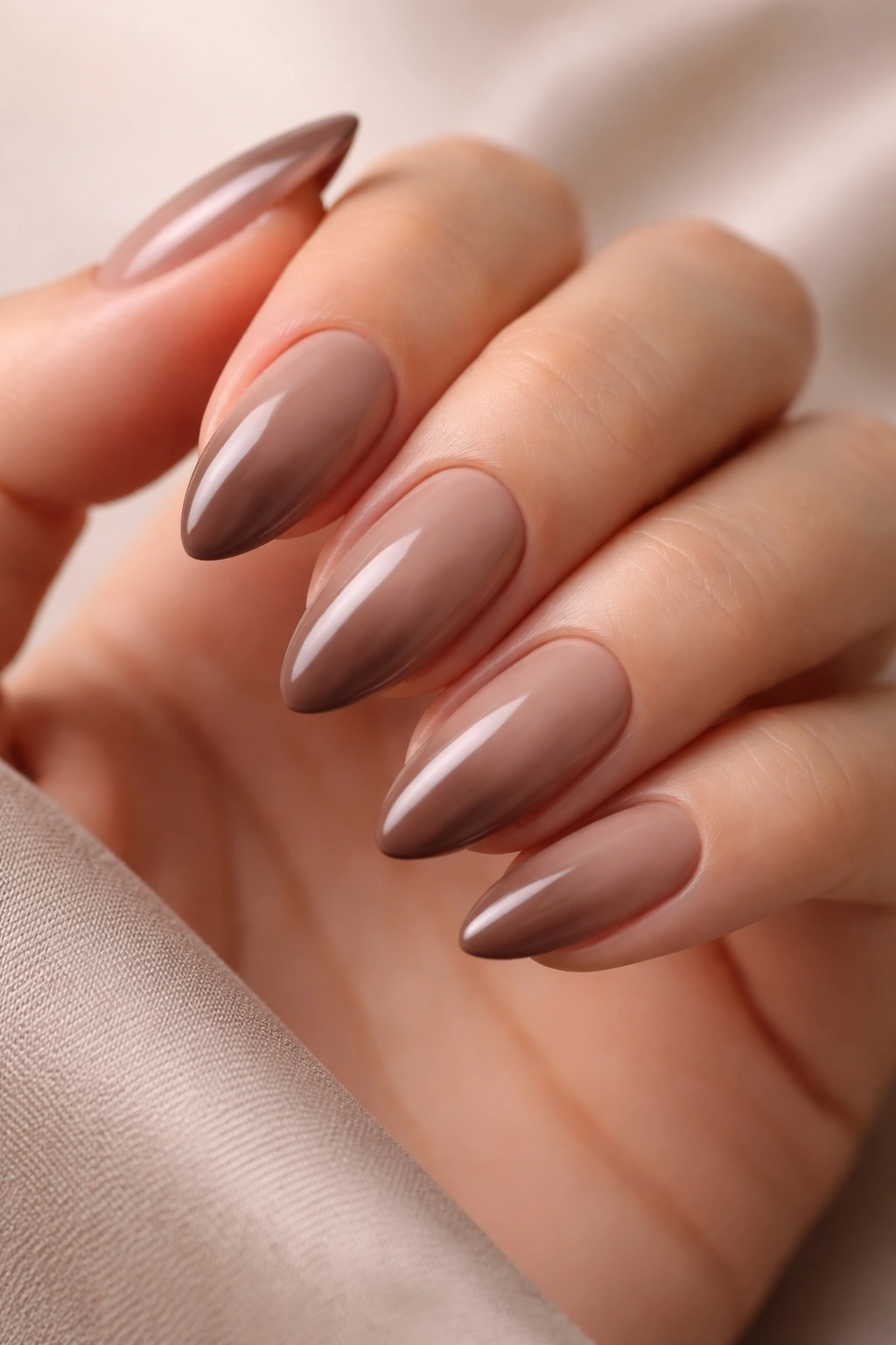 Almond nails with taupe to cocoa nude gradient in creamy finish