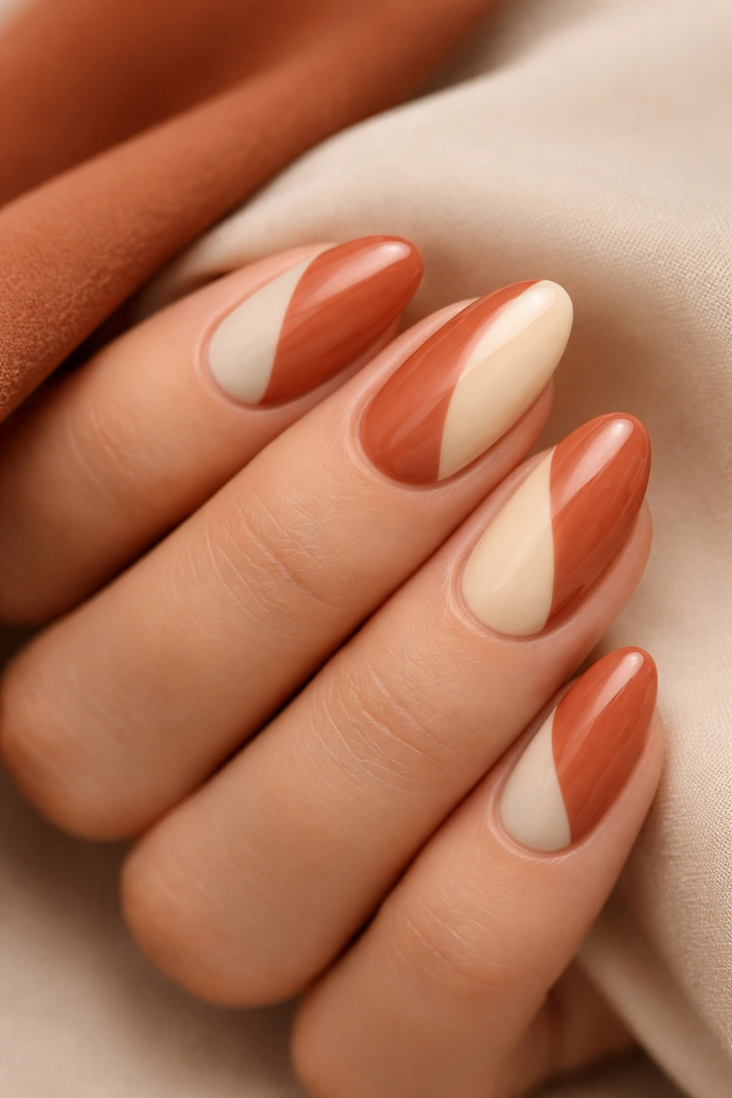 Close-up of almond nails with terracotta and cream color blocks