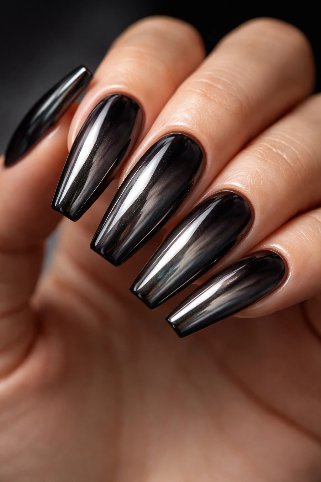 Close-up of tinted jelly black chrome nails with oil-slick depth