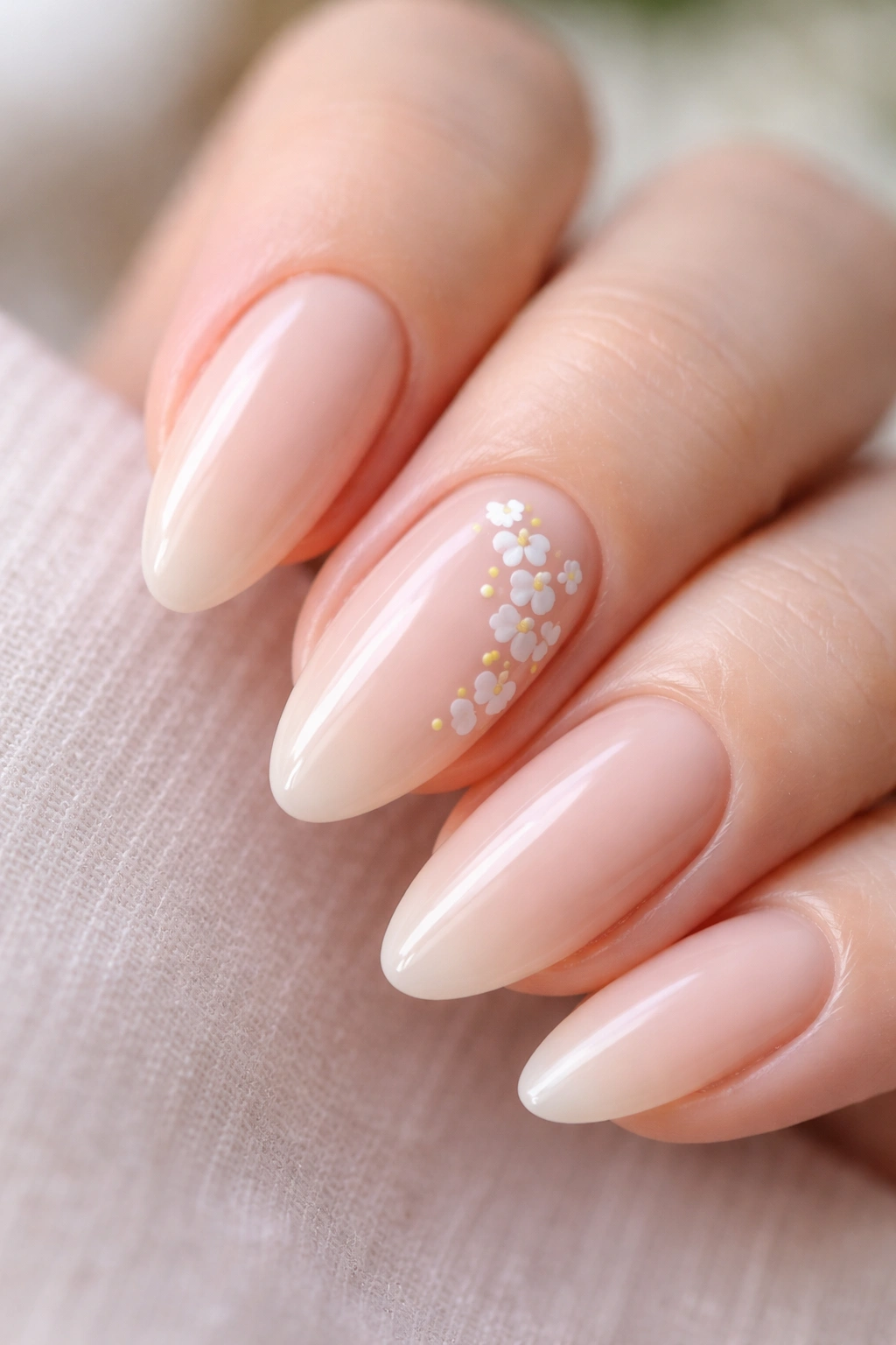 Almond nails with tiny white flowers on an accent nail