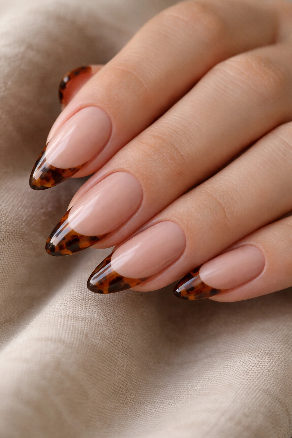 Almond nails with tortoiseshell tip pattern on nude base
