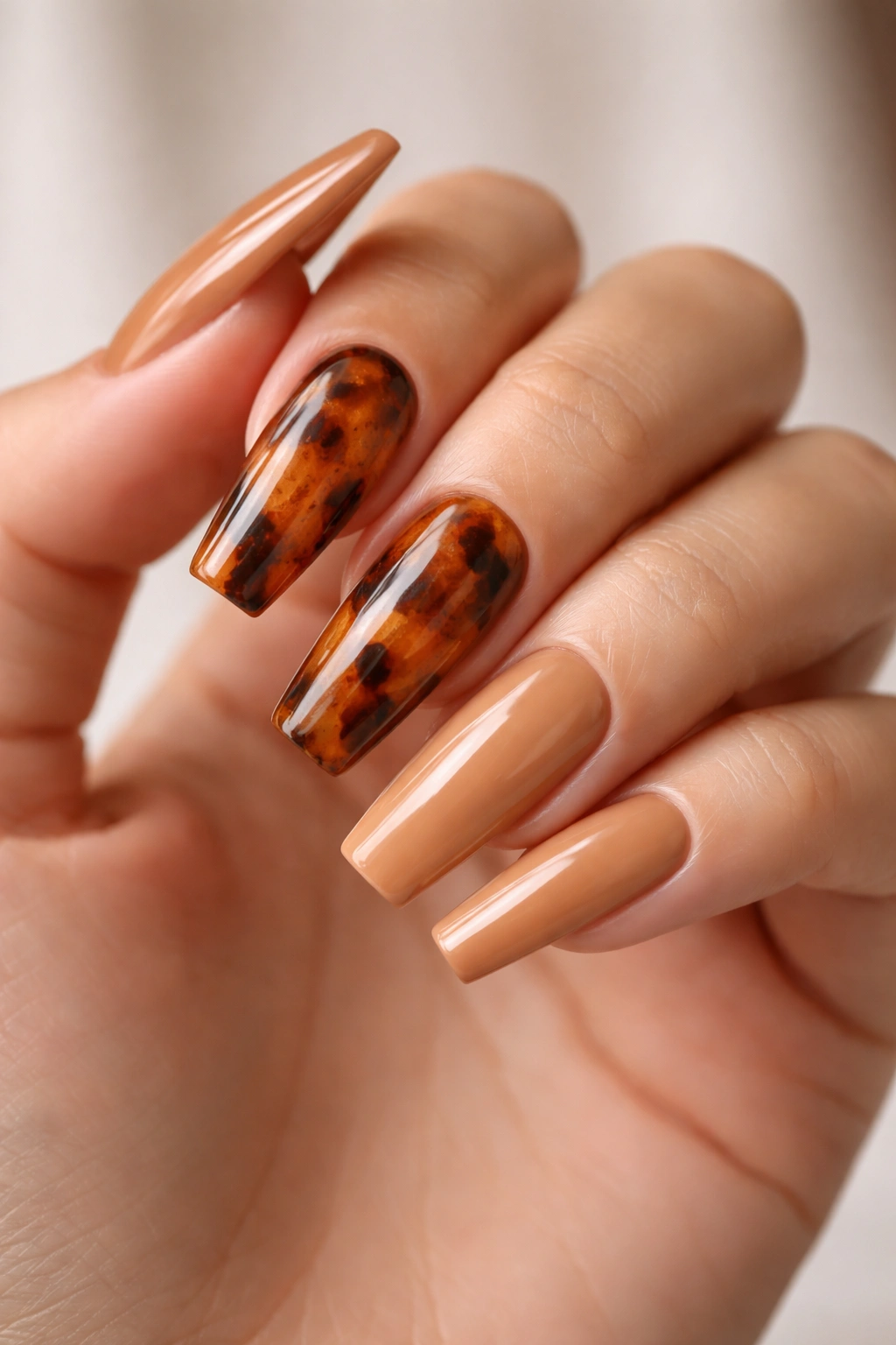 Tortoiseshell accent nails on long coffin nails with warm neutrals