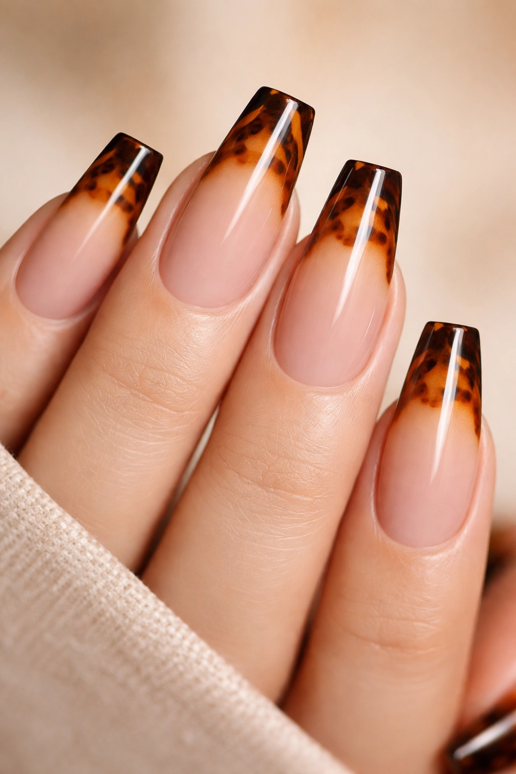 Close-up of tortoiseshell tip fade on coffin nails with amber and chestnut tones at the tip