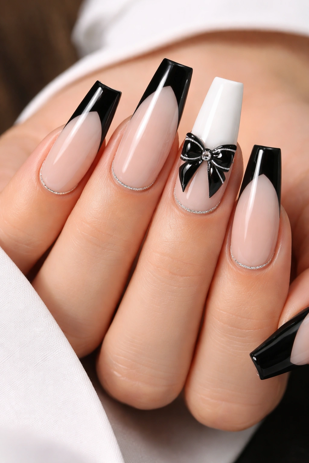 Close-up of tuxedo-inspired coffin nails with a center bow