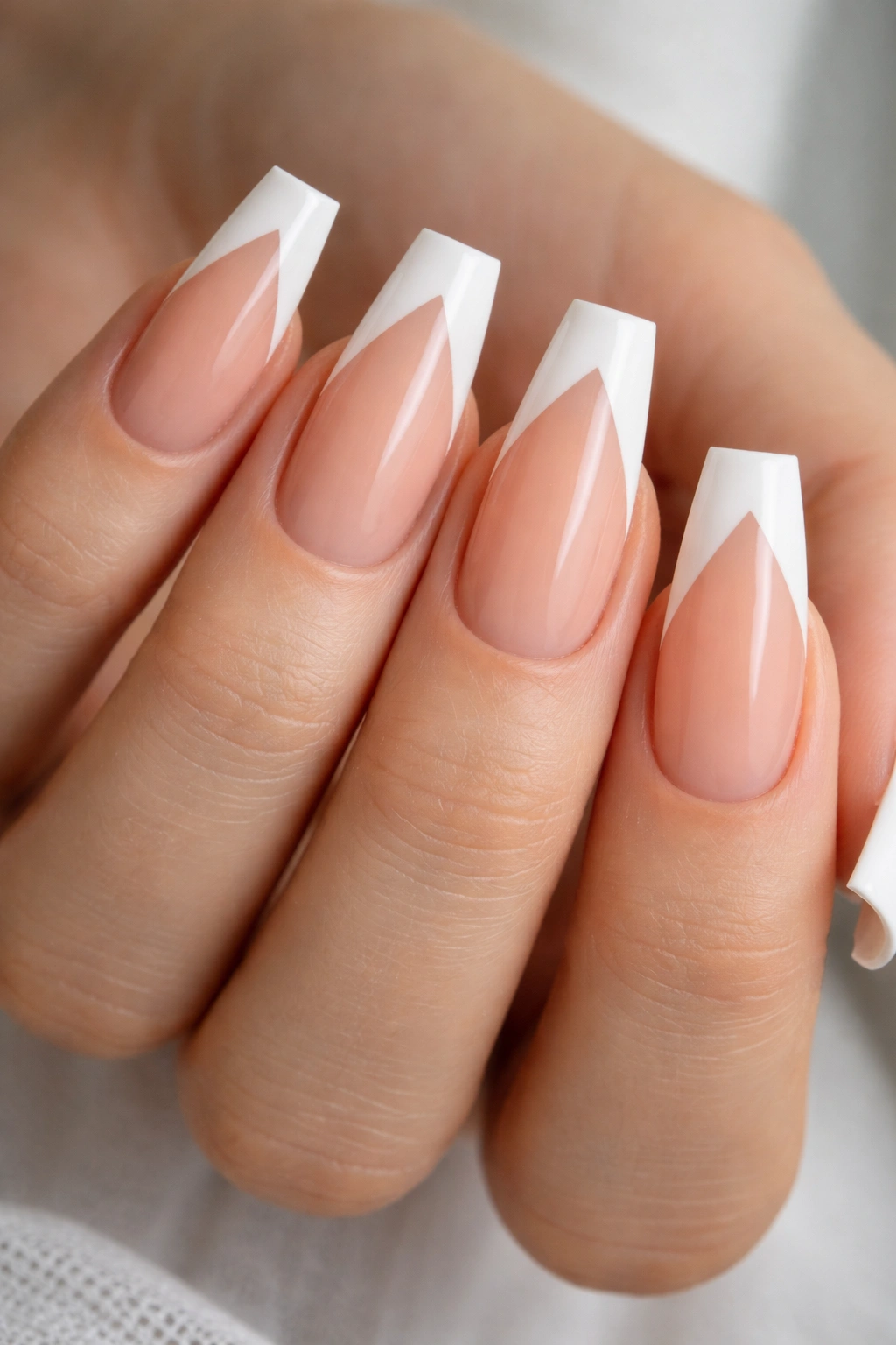 Close-up of V-cut French tips on medium coffin nails.