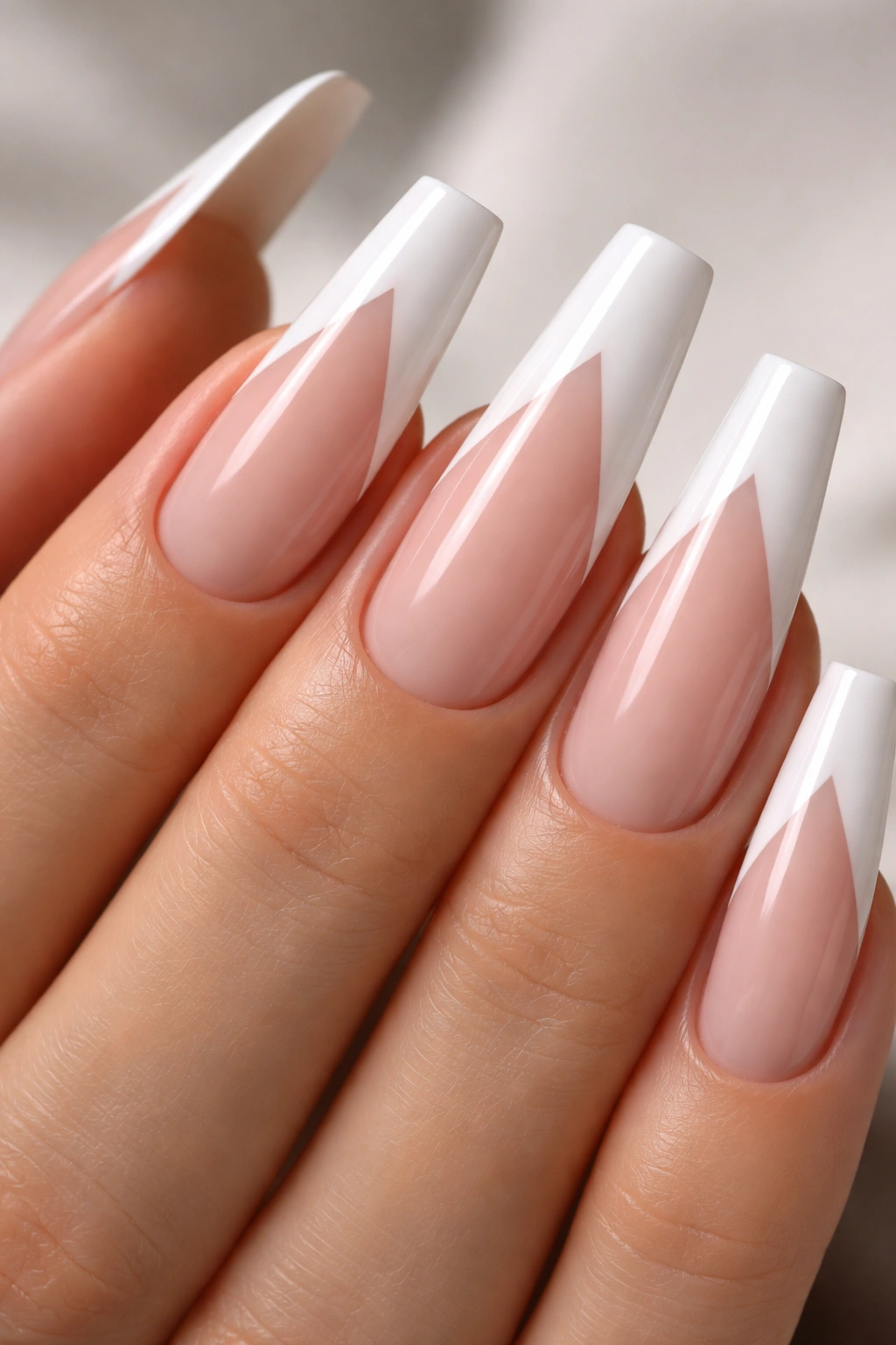 Close-up of V-shaped French tip on white coffin nails