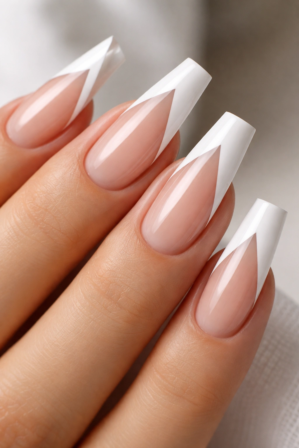 Coffin nails with a V-shaped tip and center negative space on a neutral background