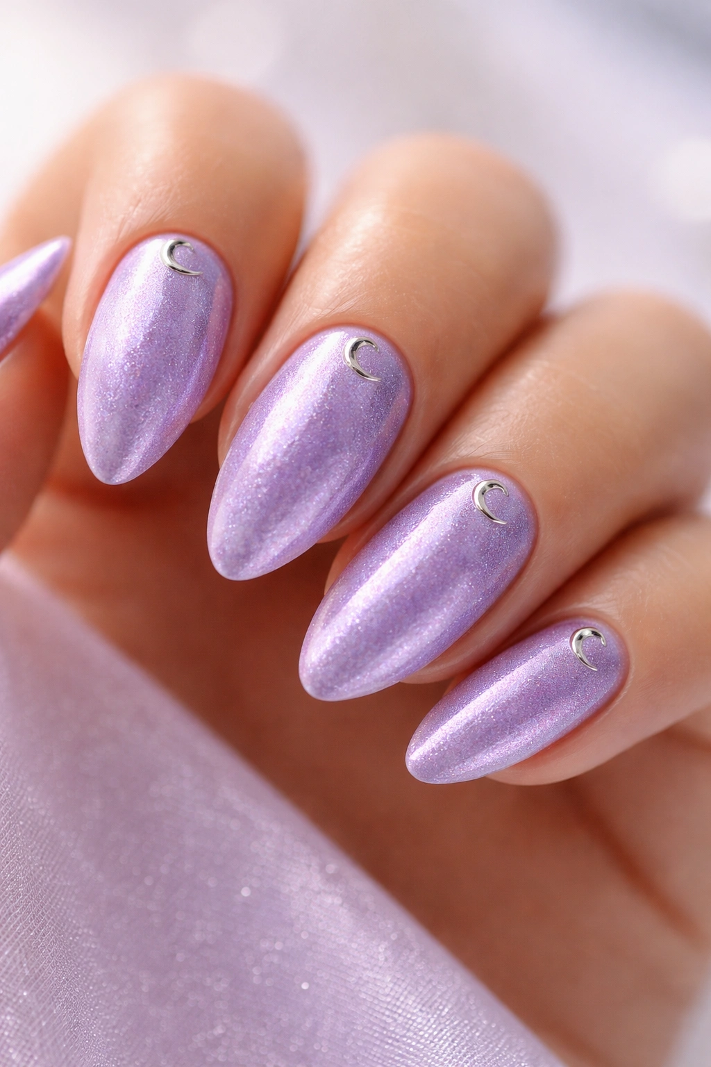 Close-up of velvet lavender almond nails with a chrome crescent near the cuticle