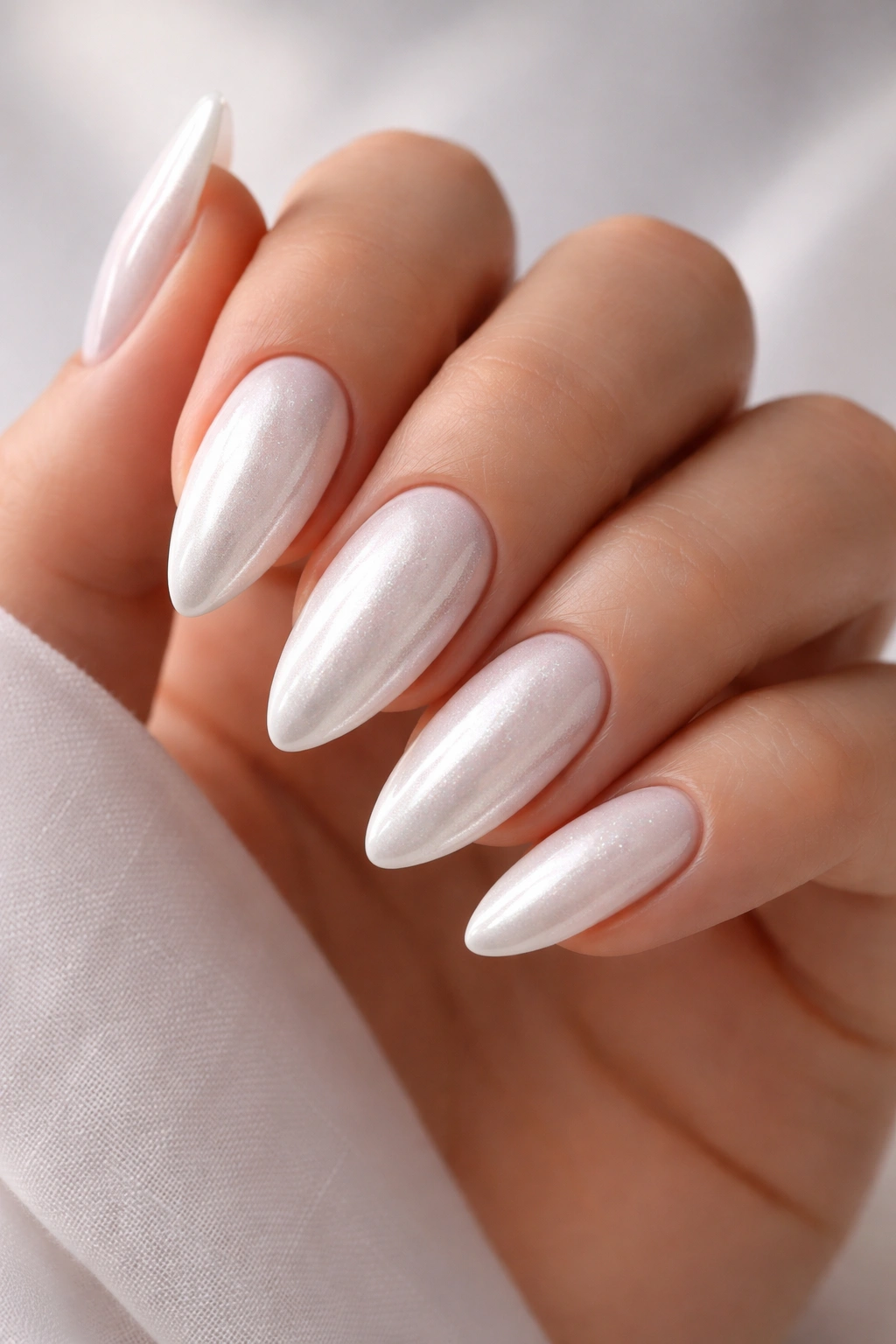 Close-up of almond nails with white chrome finish from base to tip