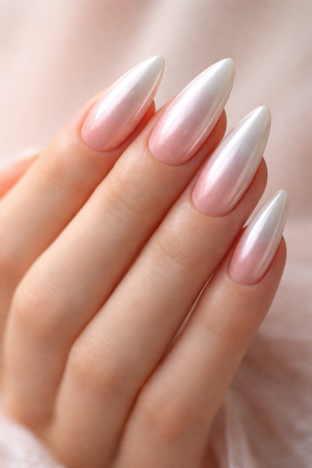 Almond nails with white chrome and subtle blush aura near the cuticle