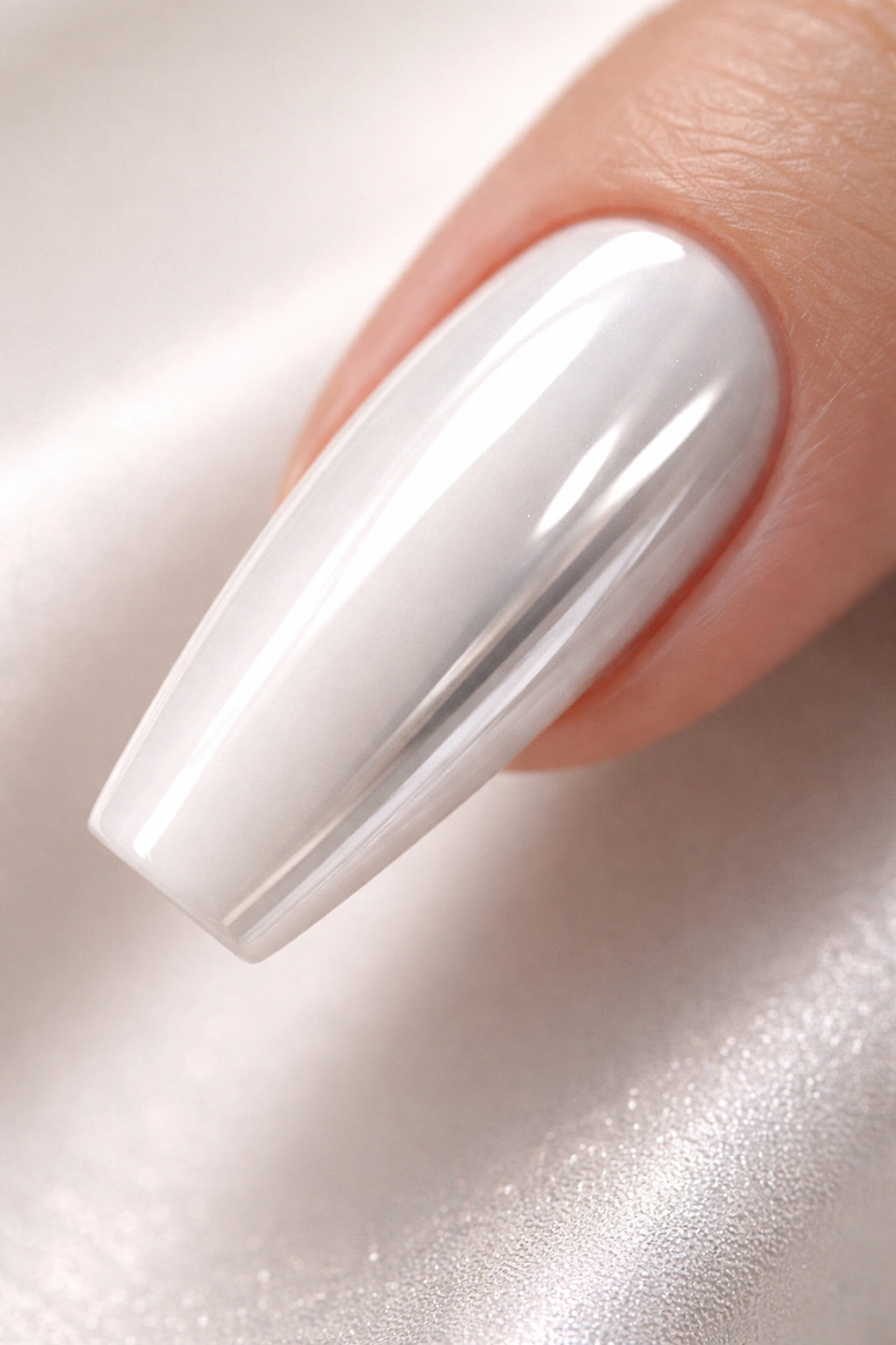 Close-up of a white chrome coffin nail with milky base and mirror chrome finish
