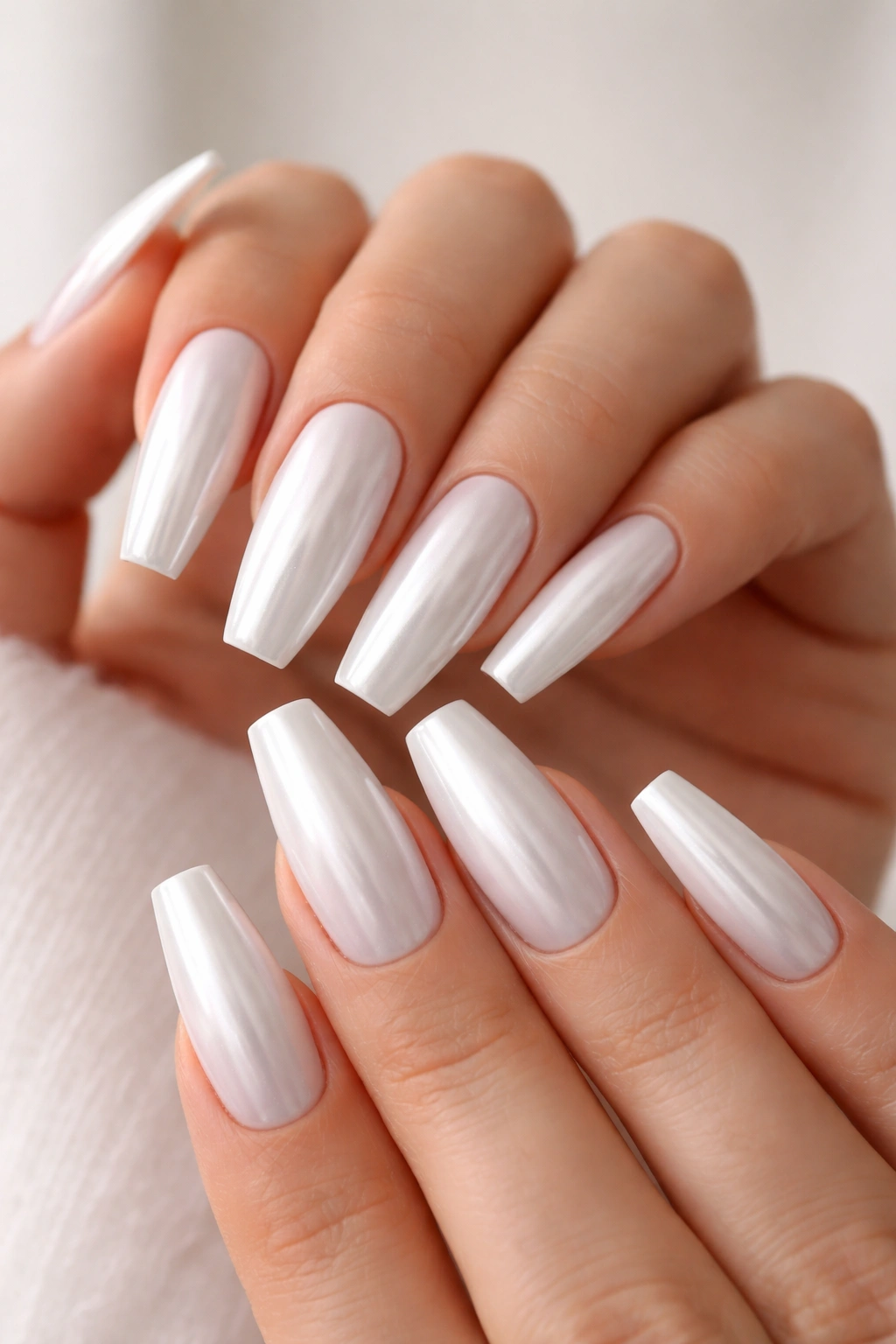 Close-up of coffin nails with pearl chrome glaze over white base