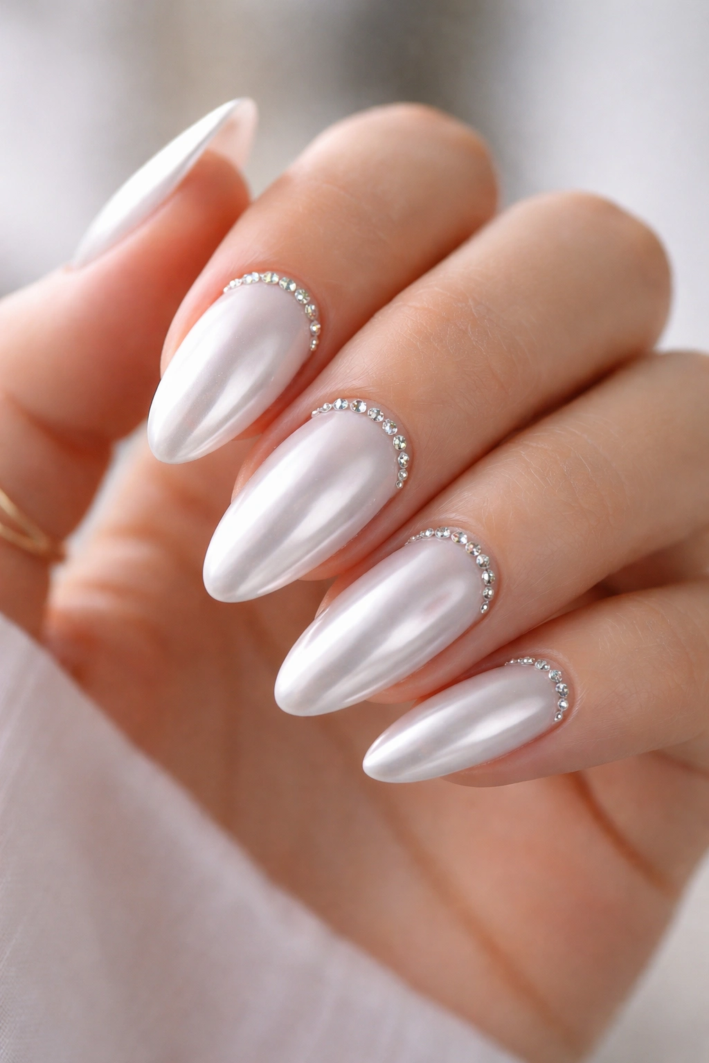 Close-up of White Chrome with Cuticle Crystals on almond nails showing a tiny crystal arc