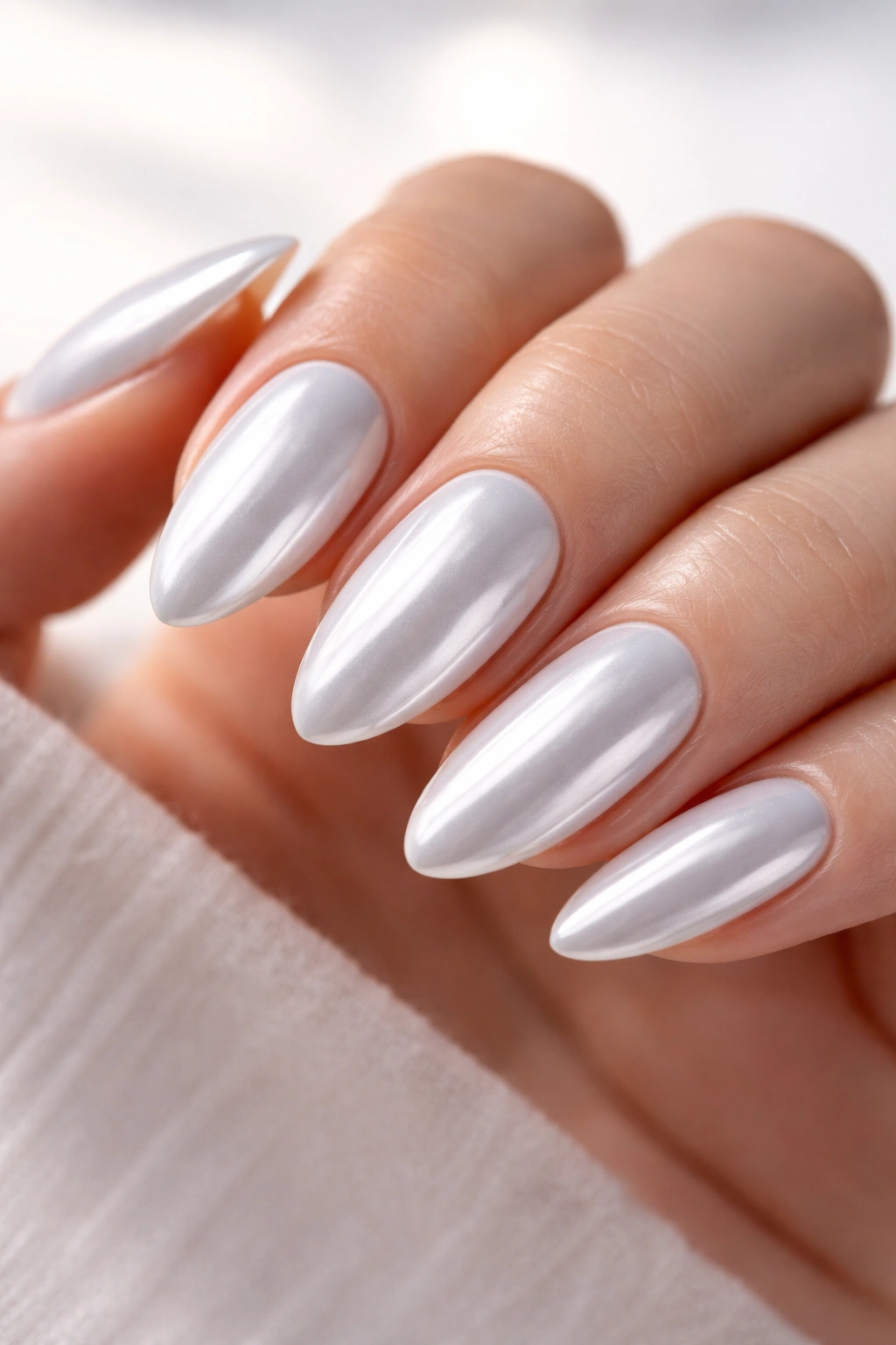Almond nails with white chrome glaze on pearl base