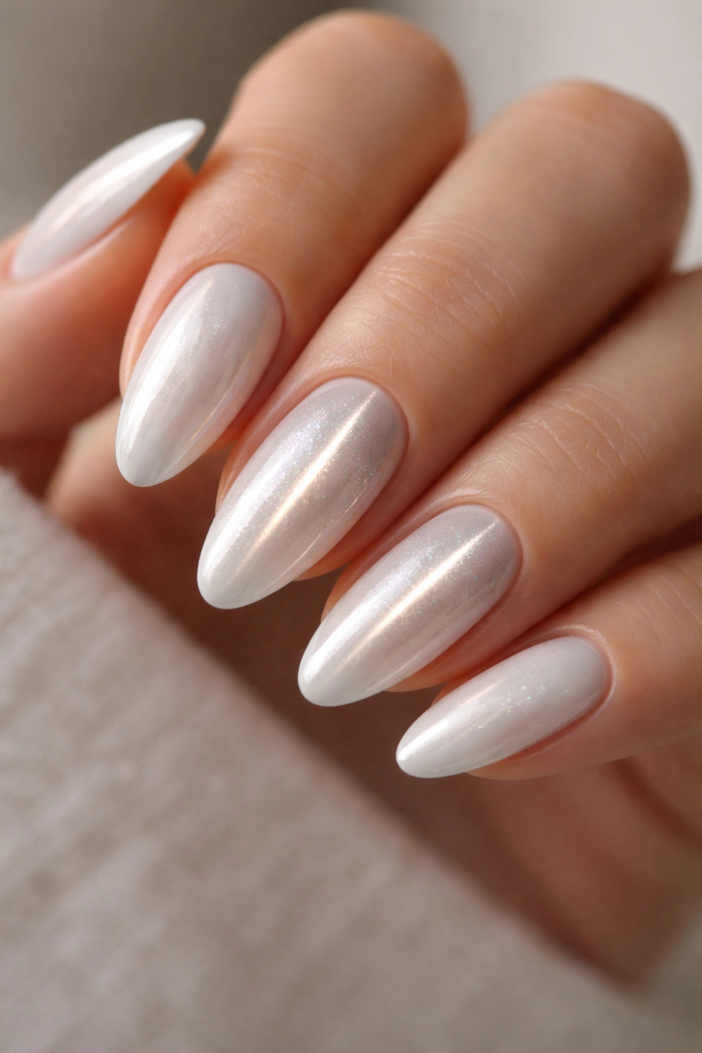 Close-up of White Chrome Cat-Eye Accent Nails on almond nails with a magnetic stripe