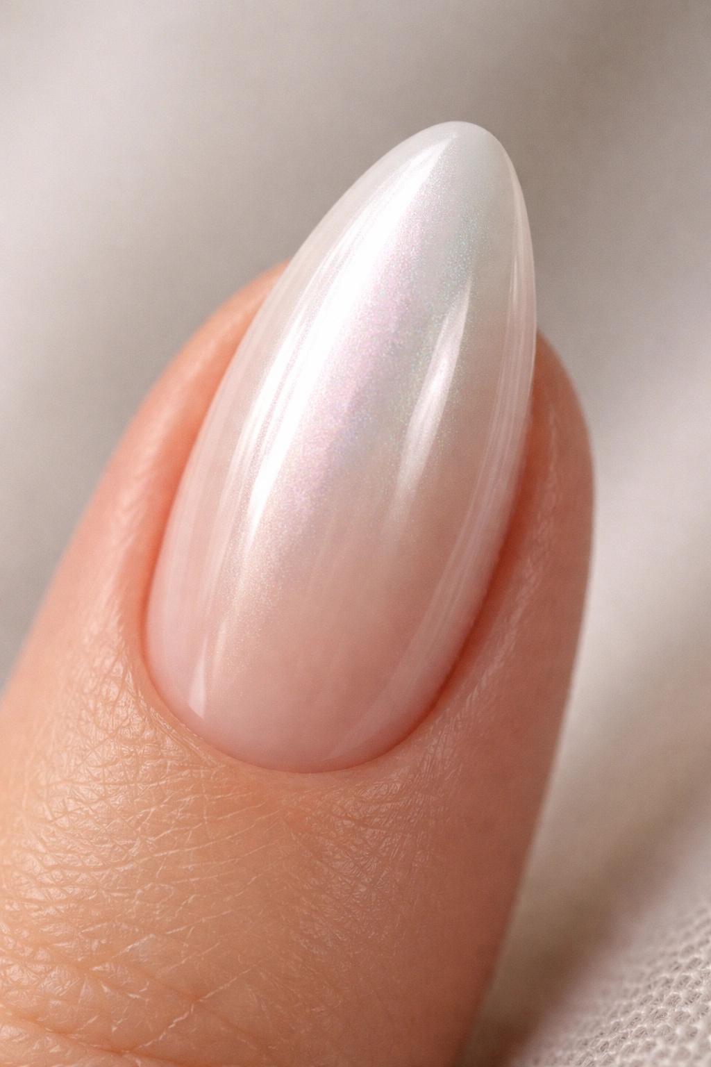 Close-up of a nail with jelly nude base and white chrome finish, translucent edges and glassy center