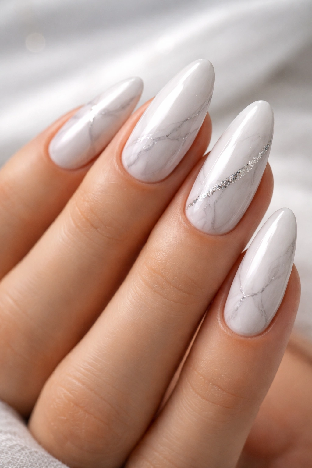 Close-up of White Chrome Marble Veining on almond nails with faint gray veins